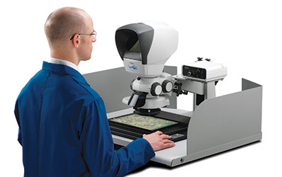 Man in blue overall using Lynx VS8 PCB stereo inspection workstation