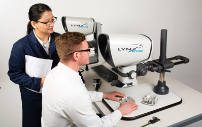 Man and woman operator looking through Lynx EVO stereo microscope